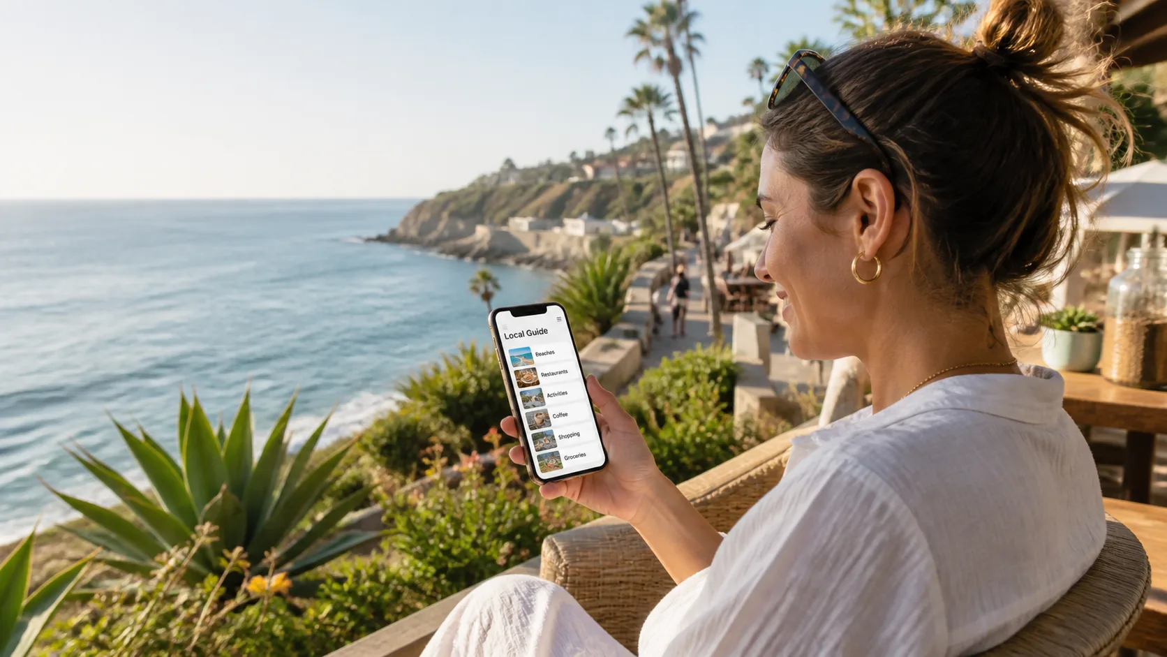 Guest browsing a local guide on Guest Portal with a coastal view.